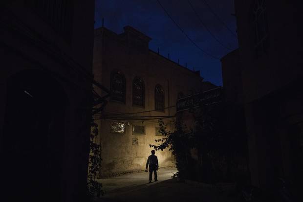 An ethnic Uyghur man walks in an alleyway near a local police station in the old town of Kashgar, in the far western Xinjiang province, China on June 27, 2017. 