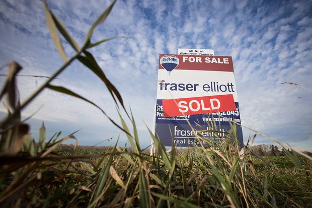 A for-sale sign stands on fallow farmland in Delta, B.C.