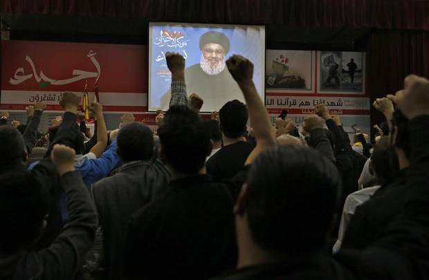 Hezbollah supporters raise their fists and cheer as they listen to a speech of Hezbollah leader Sheik Hassan Nasrallah, via a video link, during a rally marking Hezbollah Martyr's Day, in a southern suburb of Beirut, Lebanon, Friday, Nov. 10, 2017. 