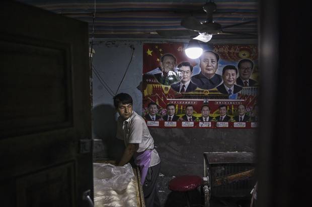 KASHGAR, CHINA - JULY 1: Under a poster showing Chinese leaders including the late Mao Zedong and the present President Xi Jinping, an ethnic Uyghur man makes bread at a local bakery on July 1, 2017 in the old town of Kashgar, in the far western Xinjiang province, China. Kashgar has long been considered the cultural heart of Xinjiang for the province's nearly 10 million Muslim Uyghurs. At an historic crossroads linking China to Asia, the Middle East, and Europe, the city has changed under Chinese rule with government development, unofficial Han Chinese settlement to the western province, and restrictions imposed by the Communist Party. Beijing says it regards Kashgar's development as an improvement to the local economy, but many Uyghurs consider it a threat that is eroding their language, traditions, and cultural identity. The friction has fuelled a separatist movement that has sometimes turned violent, triggering a crackdown on what China's government considers 'terrorist acts' by religious extremists. Tension has increased with stepped up security in the city and the enforcement of measures including restrictions at mosques. (Photo by Kevin Frayer/Getty Images)