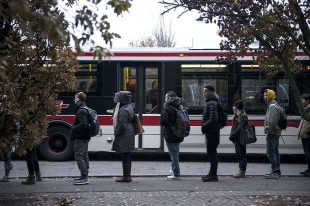 People wait in line for a TTC bus at York University.