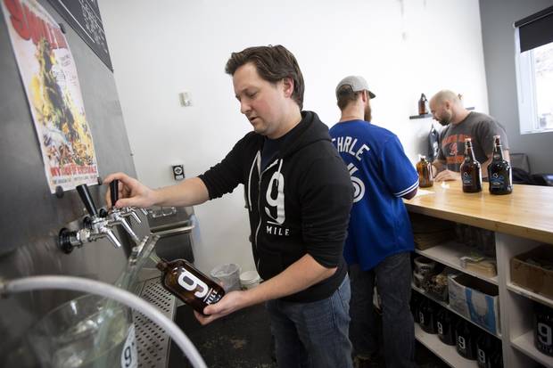 Co-founder of 9 Mile Legacy Brewing Shawn Moen fills a bottle with his craft ale. David Stobbe for the Globe and Mail